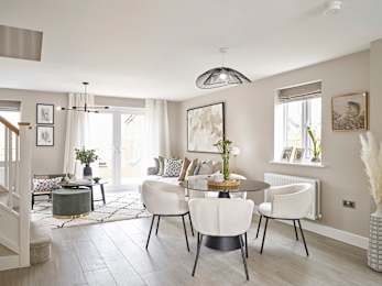 A modern dining room with a round table and white chairs.