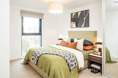 Floor Plan  A bedroom with a bed, nightstand, and a large window.