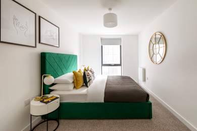 Floor Plan  a bedroom with a bed and a green tufted headboard