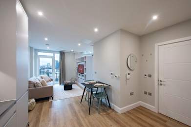 A well-lit room with a desk and a couch.
