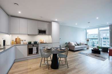 A modern kitchen with a dining table and chairs.