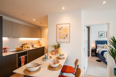 Floor Plan  A modern kitchen with a breakfast bar and a bedroom in the background.