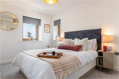A bedroom with a large bed and a tray with a cup and saucer on it.