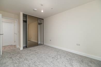 A room with a carpeted floor and a white door.