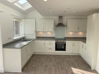 Floor Plan  A kitchen with white cabinets and a black stove top oven.