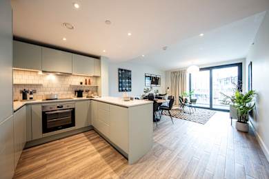 A modern kitchen with a wooden floor and white walls.