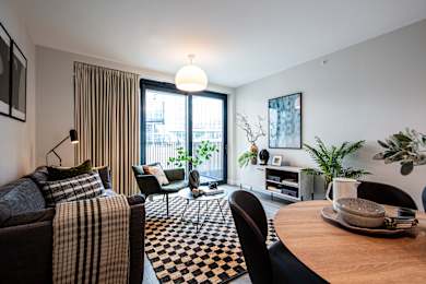 A living room with a couch, chairs, and a dining table.