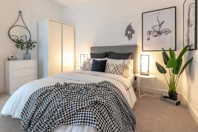 a bedroom with a bed with a black and white comforter at The Keel Apartments, Liverpool