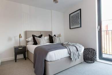 a bedroom with a large bed and a window at Vox Apartments, Manchester