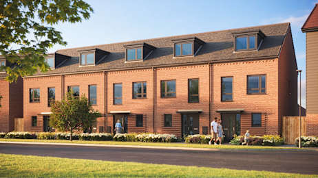 A red brick building with a green lawn in front.