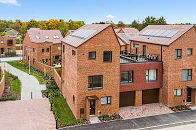 A row of red brick houses with a clear blue sky above.