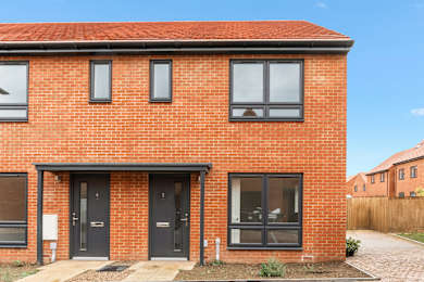 A red brick house with a black front door.