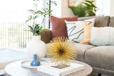 A table with a white vase, a blue vase, and a book on it.