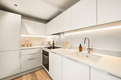Floor Plan  A modern kitchen with white cabinets and a wooden floor.