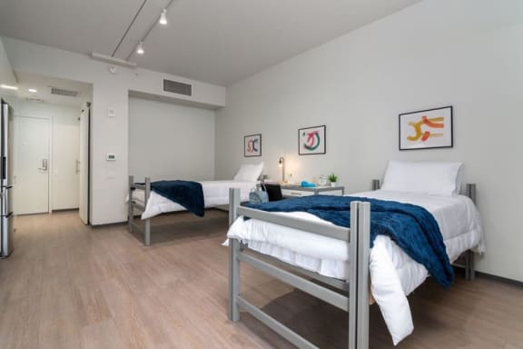 Floor Plan  a bedroom with two beds and a door to a bathroom