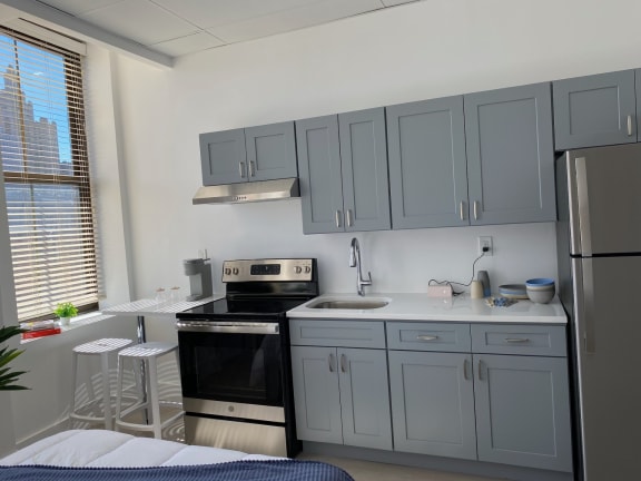 Floor Plan  a kitchen with gray cabinets and a stove and a refrigerator