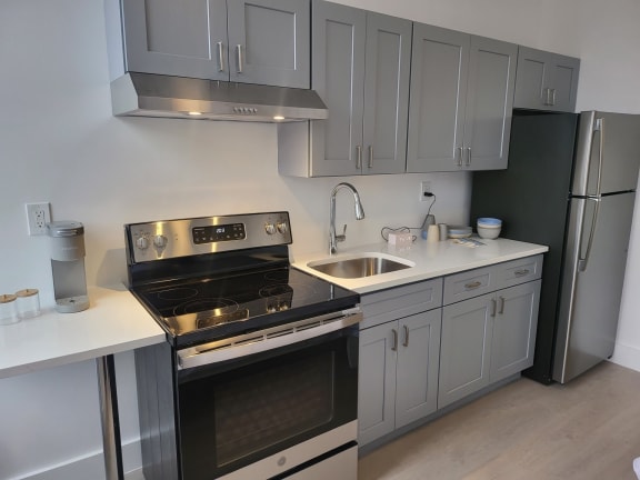 Floor Plan  a kitchen with stainless steel appliances and white cabinets