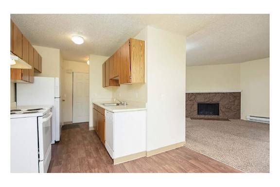 Floor Plan  A kitchen with white appliances and wooden cabinets.