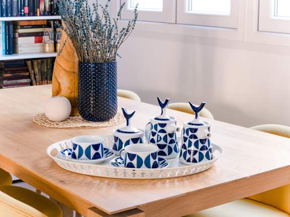 A table with a blue and white patterned set of cups and saucers.