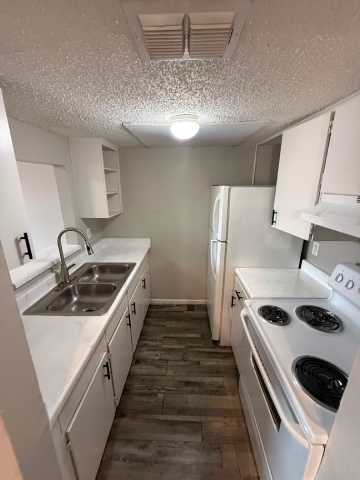 Floor Plan  A kitchen with white cabinets and a stove top oven.