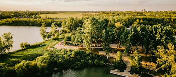 A serene landscape with a lake, trees, and a park area.