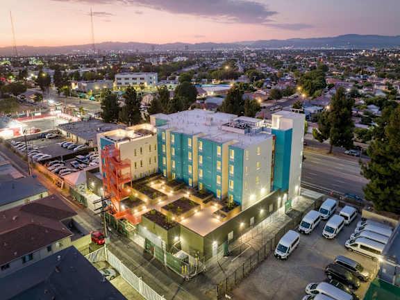 Floor Plan  A parking lot with cars and a multi-story building with a red awning.