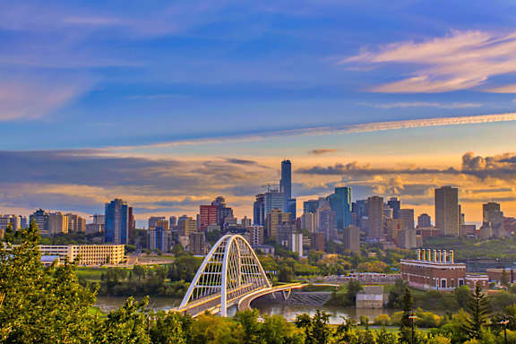 A city skyline with a bridge crossing a river.
