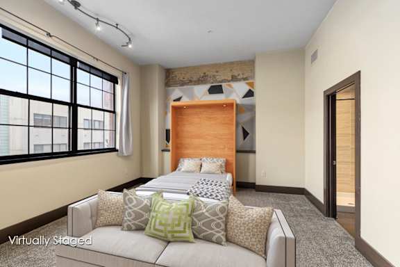 Floor Plan  A bedroom with a large bed and a window with blinds.