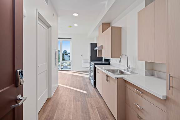 Floor Plan  A modern kitchen with wooden floors and a white countertop.