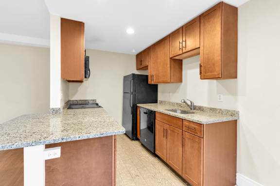 Floor Plan  A kitchen with a granite countertop and wooden cabinets.