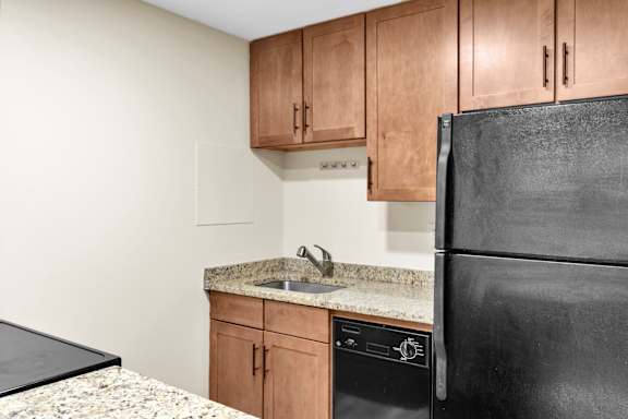 Floor Plan  A black refrigerator sits next to a black countertop.