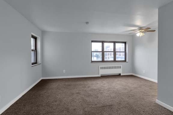 Floor Plan  A room with a ceiling fan and a window with a view of a building outside.