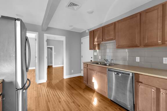Floor Plan  A kitchen with wooden cabinets and a stainless steel dishwasher.