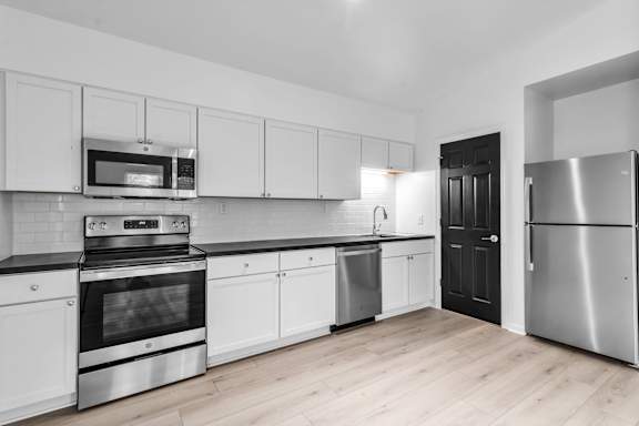Floor Plan  A modern kitchen with stainless steel appliances and white cabinets.