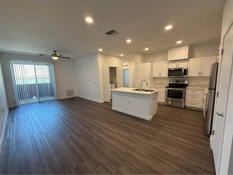 Floor Plan  A spacious kitchen with white cabinets and a wooden floor.
