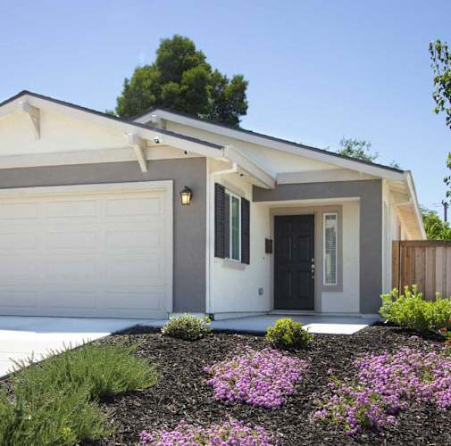 A house with a grey and white exterior and a black door.