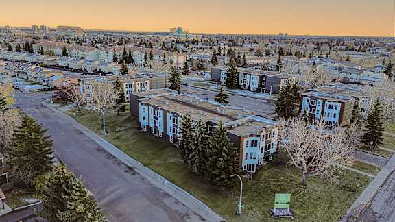 A view of a residential area with apartment buildings and trees.