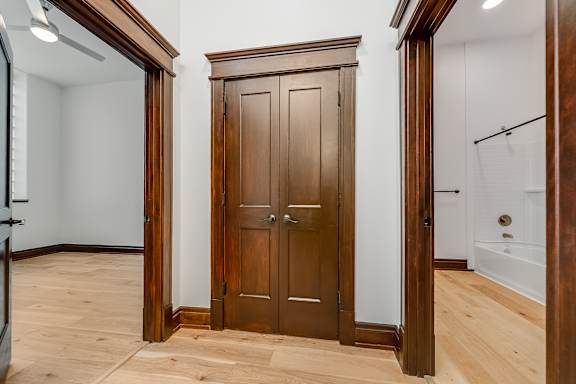 Floor Plan  A wooden wardrobe stands in a room with a white wall and wooden floor.