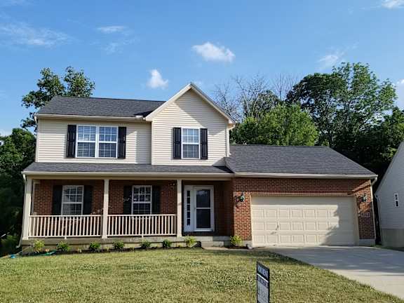 Floor Plan  A house with a white garage door and a brown brick chimney.