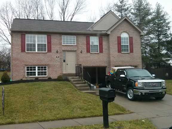 Floor Plan  A house with red shutters and a black truck parked in front.