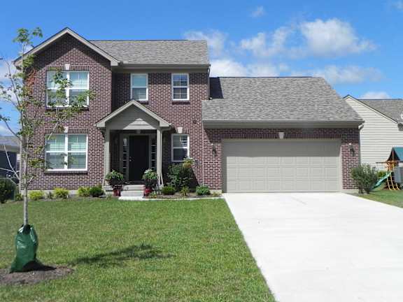 Floor Plan  A house with a grey garage door and a tree in a green bag.
