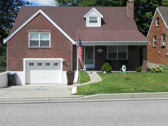 Floor Plan  A red brick house with a white garage door.