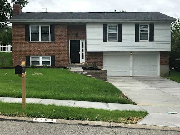 Floor Plan  A brick house with a white garage door.