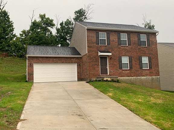 Floor Plan  A brick house with a white garage door.