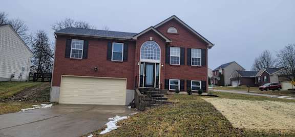 Floor Plan  A red brick house with a white garage door.