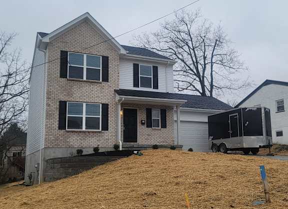 Floor Plan  A house with a brick facade and a garage door.