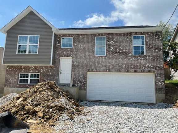 Floor Plan  A house with a garage and a pile of gravel in front.