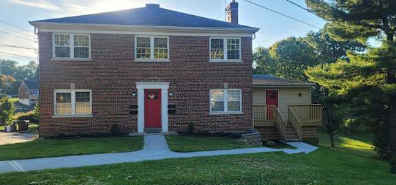 Floor Plan  A brick house with a red door and a small porch.