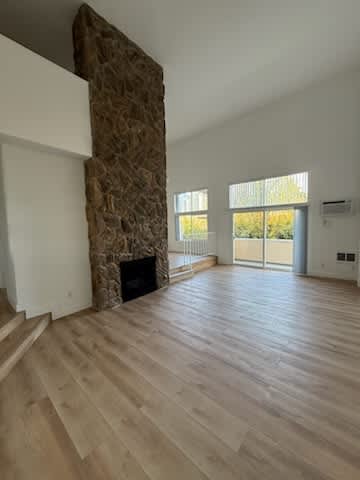 Floor Plan  Living room with stone fireplace and wood flooring