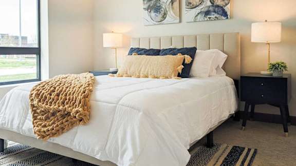 a bedroom with a large bed and two lamps